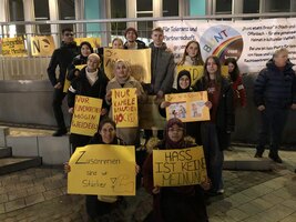 Gruppe Jugendlicher mit und ohne Kopftuch bei einer demonstrieren mit Schildern