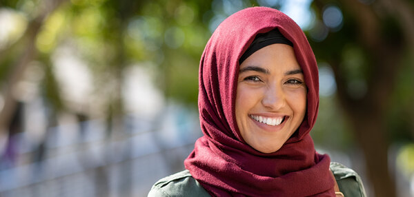 Junge lächelnde muslimische Frau im Grünen