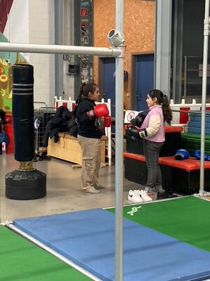 Zwei junge M&auml;dchen in einer Turnhalle mit Boxhandschuhen