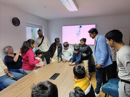 Eine Gruppe Kinder beim Bau eines Roboters unter Anleitung zweier Erwachsener