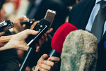 Ein Mensch wird mit vielen Mikrofonen interviewt