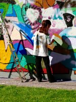 Junges M&auml;dchen bemalt eine Wand