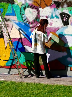 Junges M&auml;dchen bemalt eine Wand